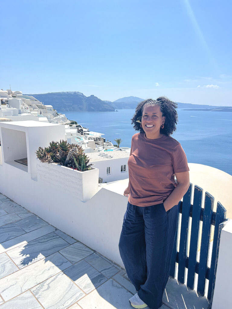 Santorini blue gate Women standing by blue gate in Santorini, Greece